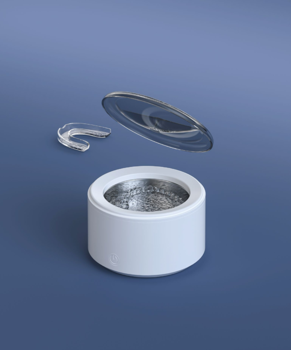 Cordless Ultrasonic Retainer Cleaner in Use M9C5101 cordless ultrasonic retainer cleaner with open lid and clear aligner