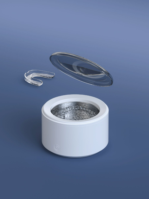 Cordless Ultrasonic Retainer Cleaner in Use M9C5101 cordless ultrasonic retainer cleaner with open lid and clear aligner